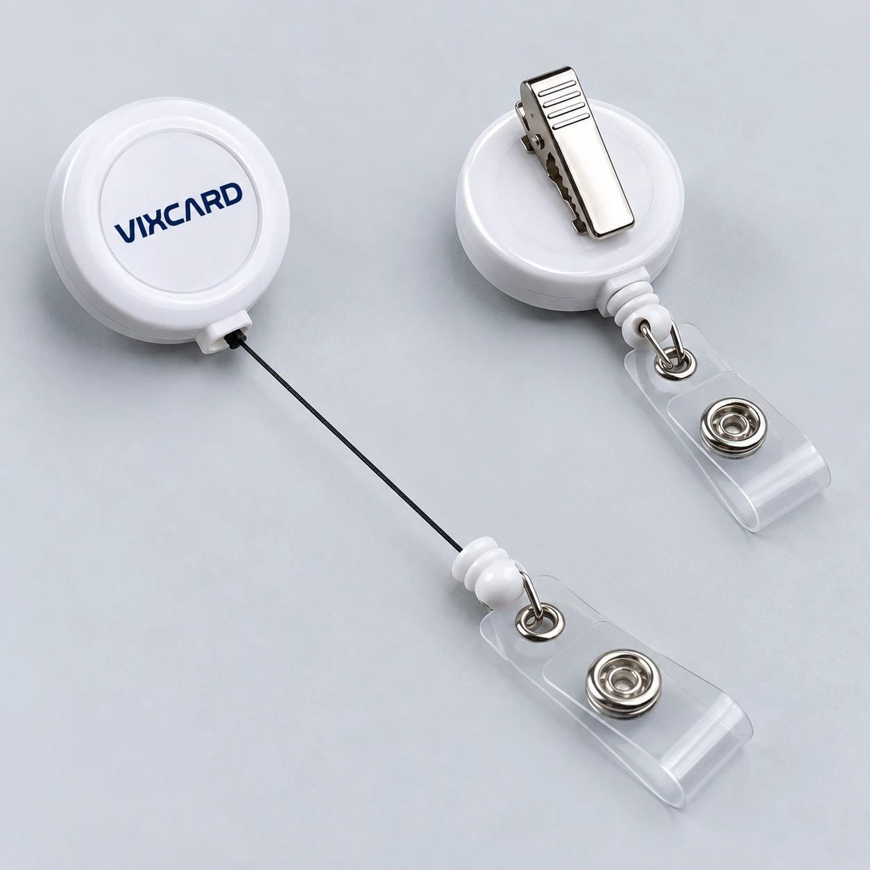 Clips retrátil branco com alça de vinil transparente e presilha jacaré, logo Vixcard na tampa